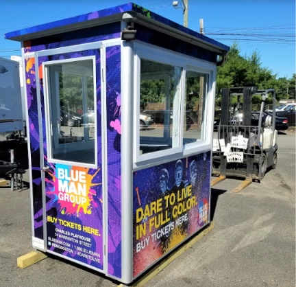 A blue and purple ticket booth with Blue Man Group signs