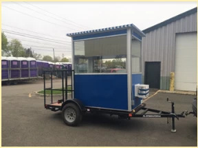 A blue booth on a trailer with big wheels
