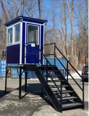A dark blue booth at the top of an elevated platform with stairs