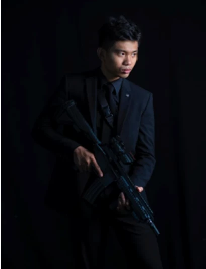 A man in a suit holding a rifle