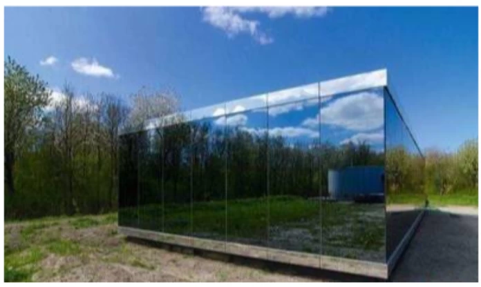 A mirrored building in the woods