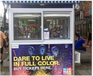 A ticket booth with Blue Man Group advertisement