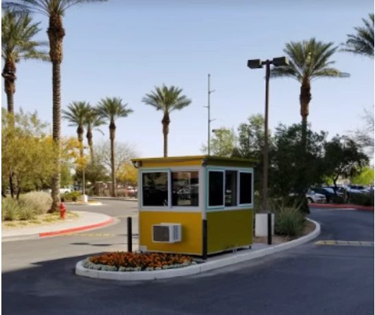 A yellow guard shack at a parking lot entrance