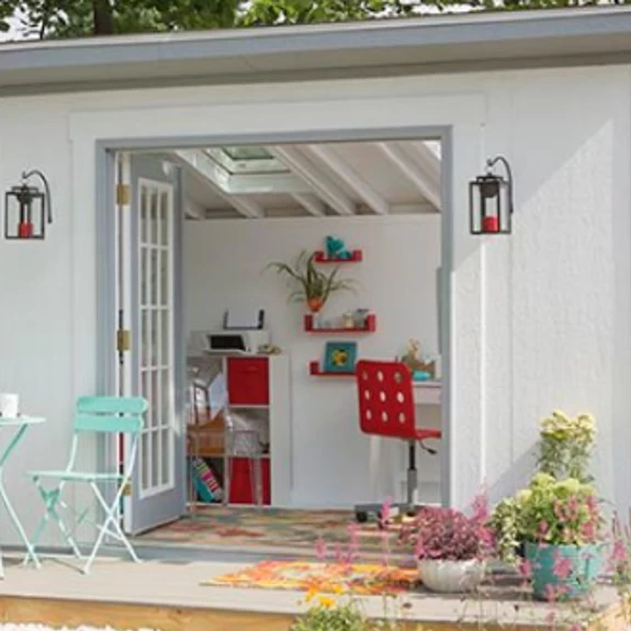 Airy backyard she shed for sale with open doors and red accents
