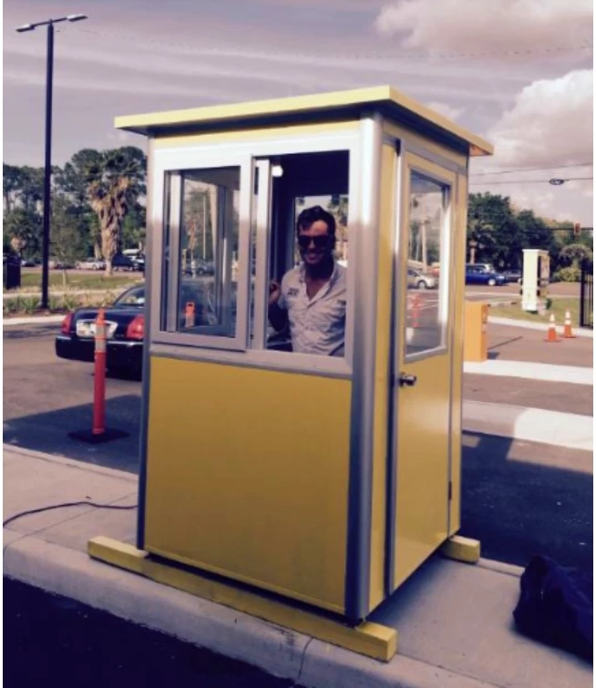 Parking attendant standing in a yellow booth
