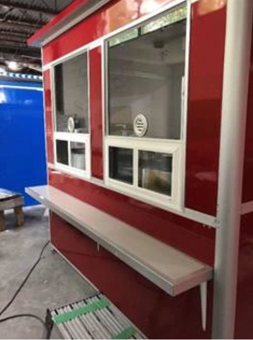 Red ticket booth with window speaker and customer counter.