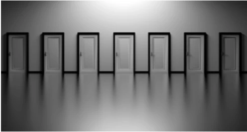 Seven white doors with black outlines lined up in a row