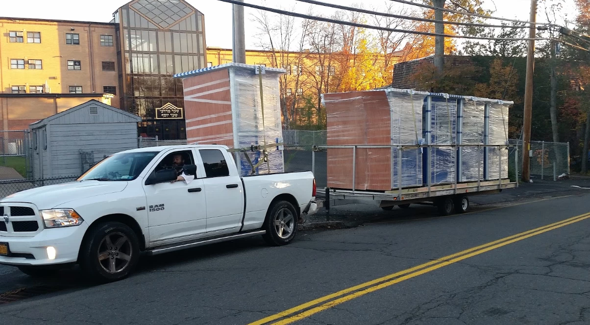 Shrink wrapped blue ticket booths being towed by a truck