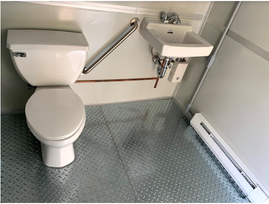 White bathroom with metal floor, white sink and toilet