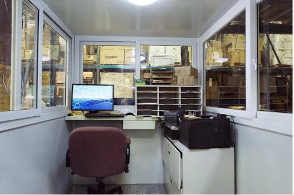 Interior of a prfabricated guard shack turned into a working station with desk and chair. 
