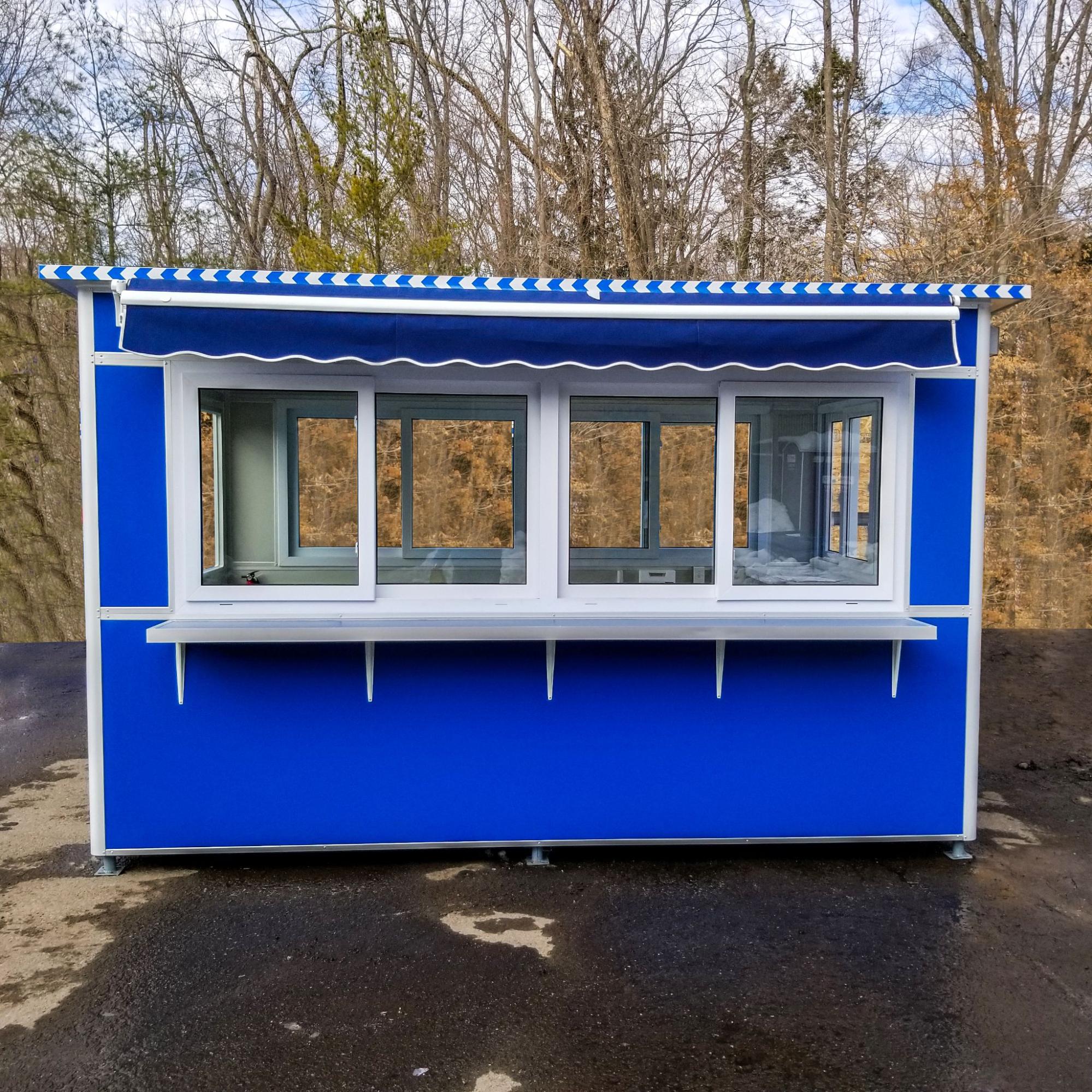 A-blue-prefabricated-booth-featuring-large-sliding-windows-and-a-striped-roll-up-awning